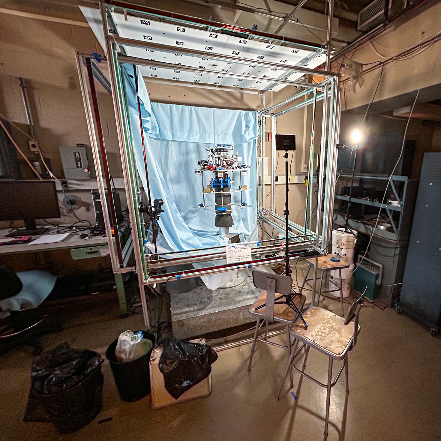 Lighting fixtures and blue bed sheet used as uniform background in an effective technical photograph of a laboratory hardware setup.